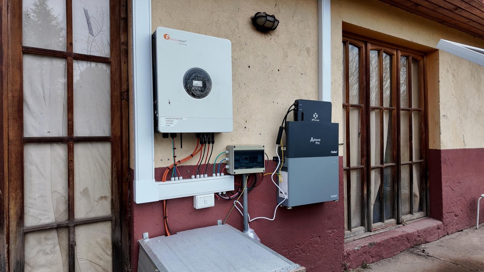 Inversor y batería instalados en el muro exterior de una casa